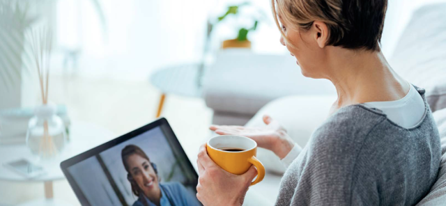 Woman drinking coffee while watching a video